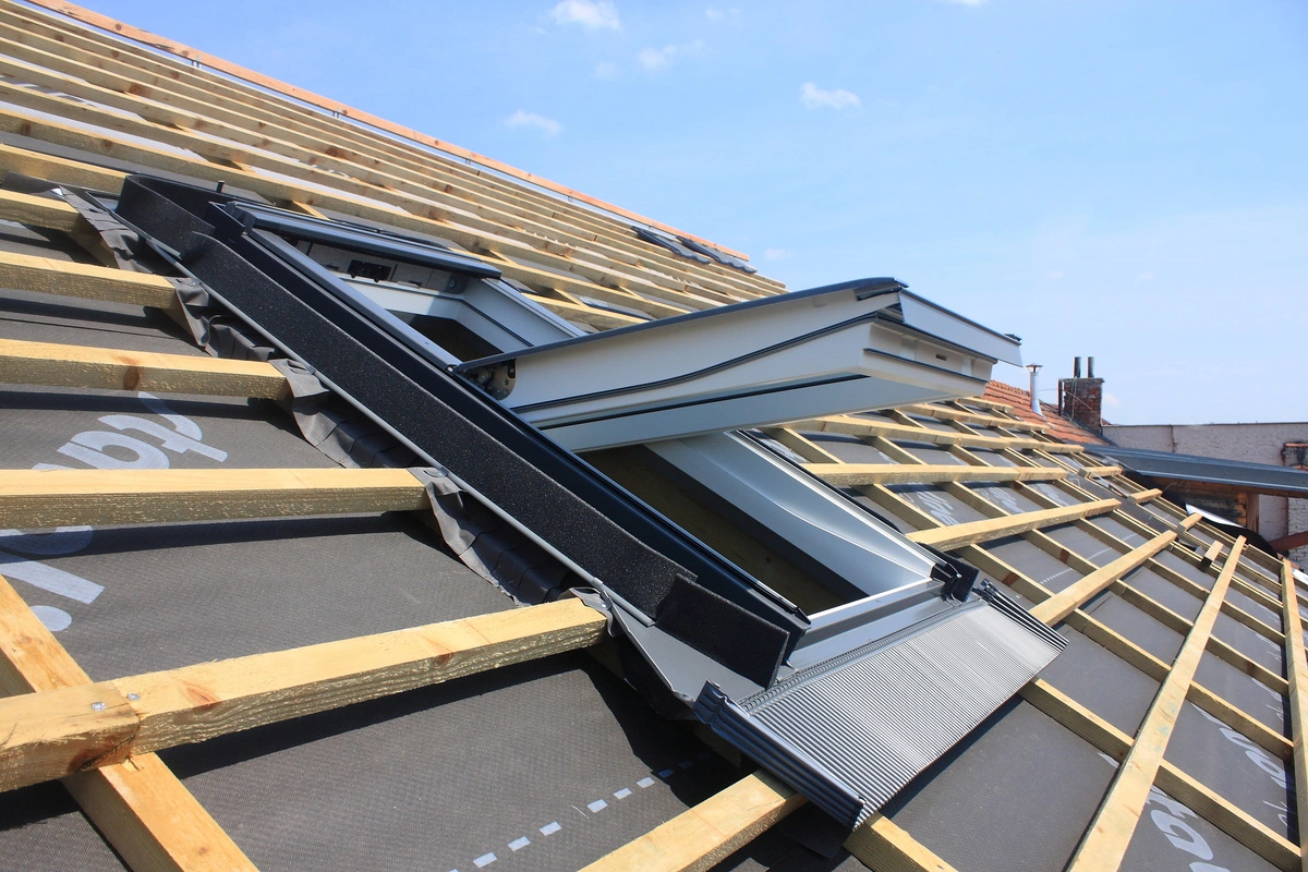 Pose de Velux sur une toiture en construction.